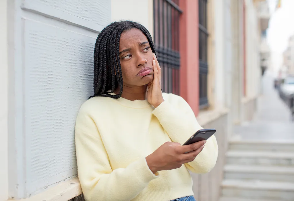 A woman looking distressed when using her phone